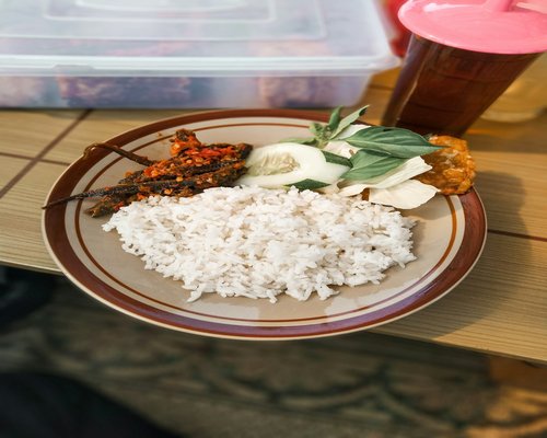 A standard Indonesian lunch box with rice, vegetables, and chicken
