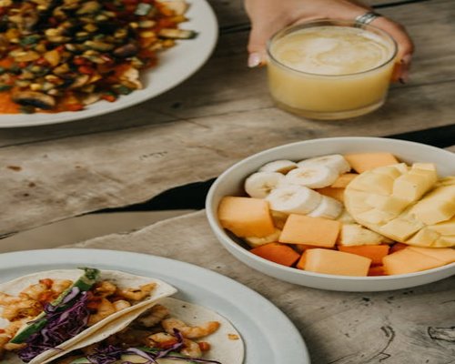 Sliced papaya and mango served on a rustic wooden table